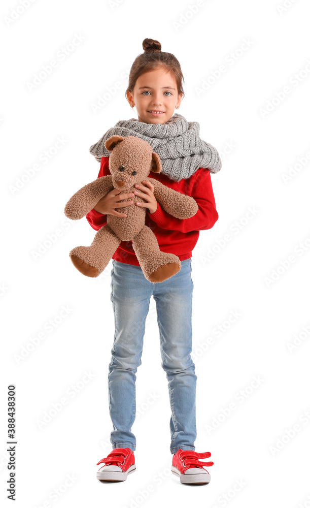 Cute girl in winter clothes and with toy on white background