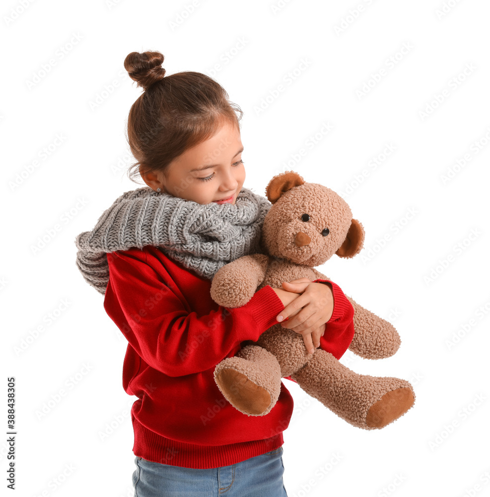 Cute girl in winter clothes and with toy on white background