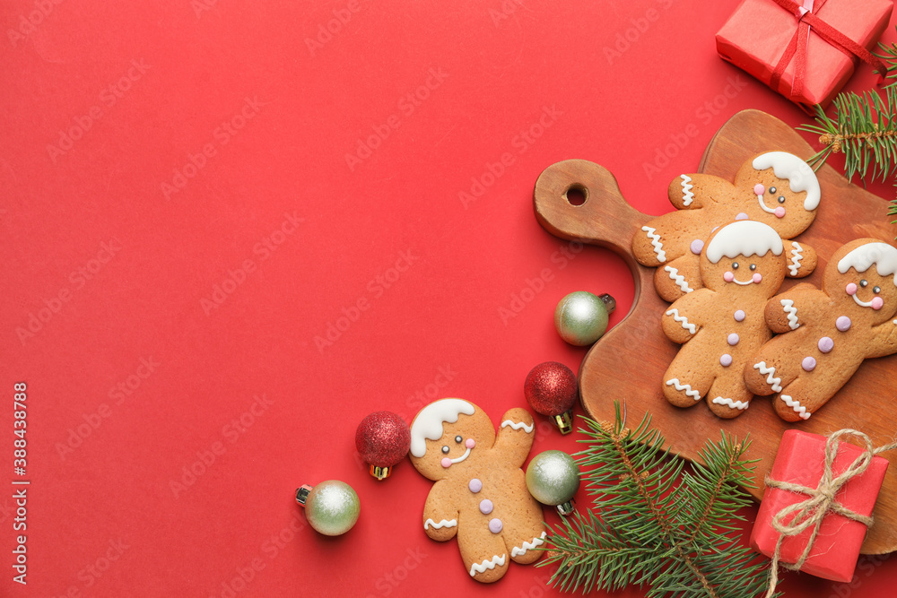 Tasty gingerbread cookies and Christmas decor on color background