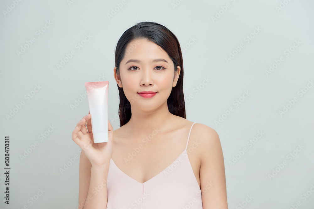 Beautiful portrait young asian woman holding and presenting cream or lotion product