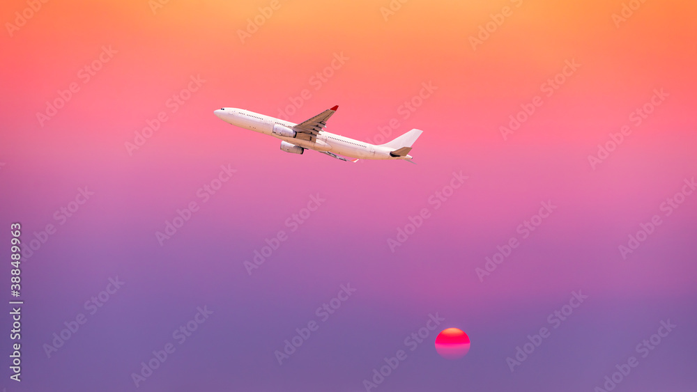 Commercial airplane flying above clouds in colorful sunset.Travel,holidays and business concept.