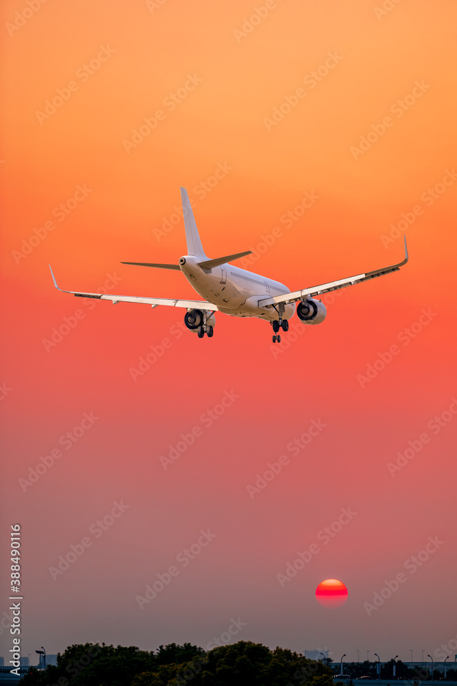 Commercial airplane flying above clouds in colorful sunset.Travel,holidays and business concept.