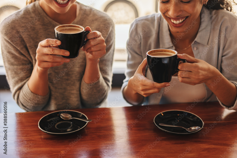 Friends at cafe table drinking coffee