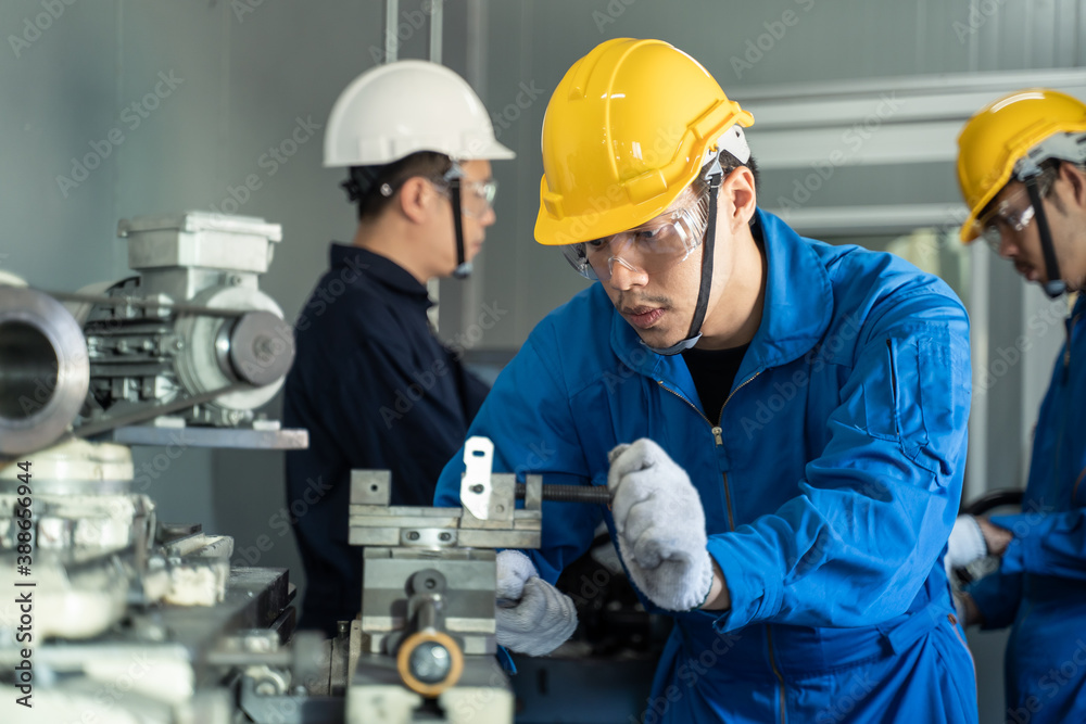 Asian mechanical workers working on milling machine with carefully.