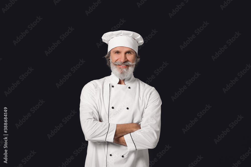 Mature male chef on dark background