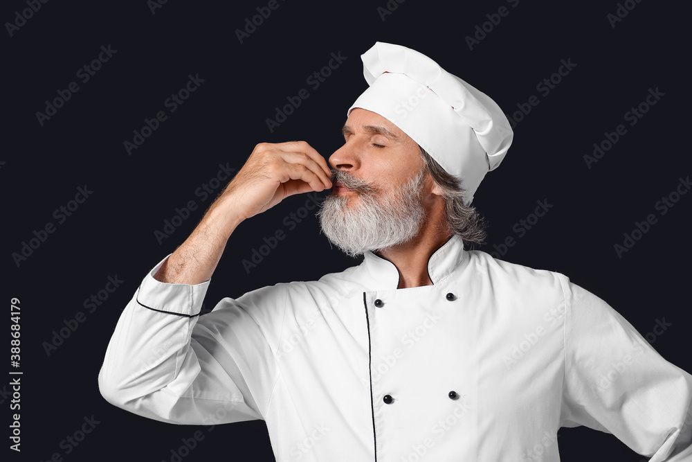 Mature male chef on dark background