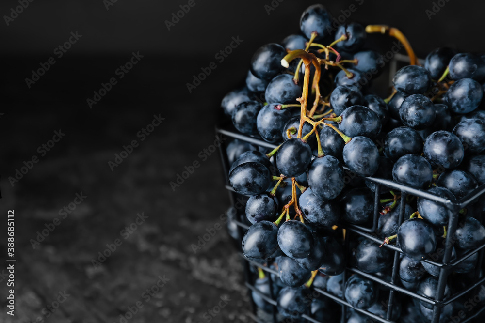 Basket with sweet ripe grapes on table