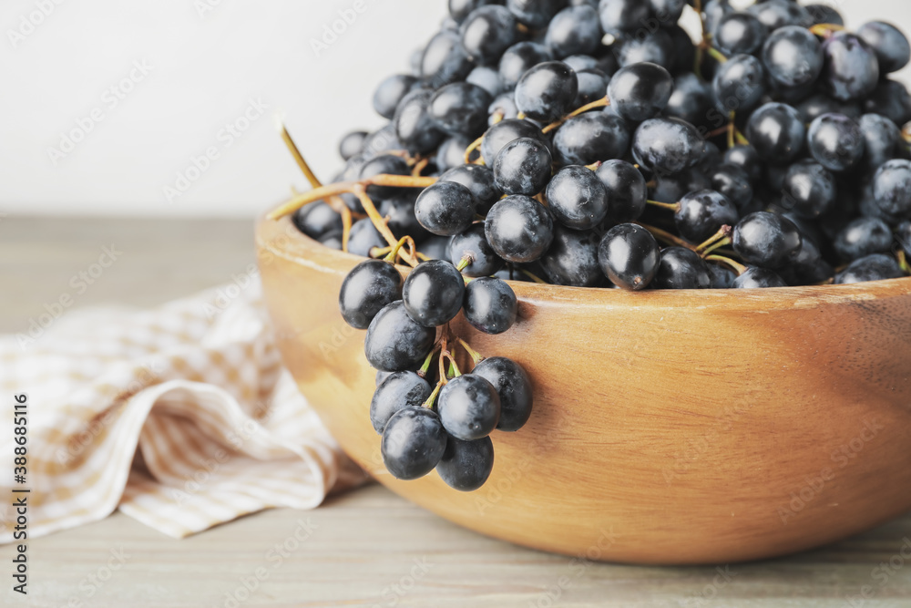 Bowl with sweet ripe grapes on table