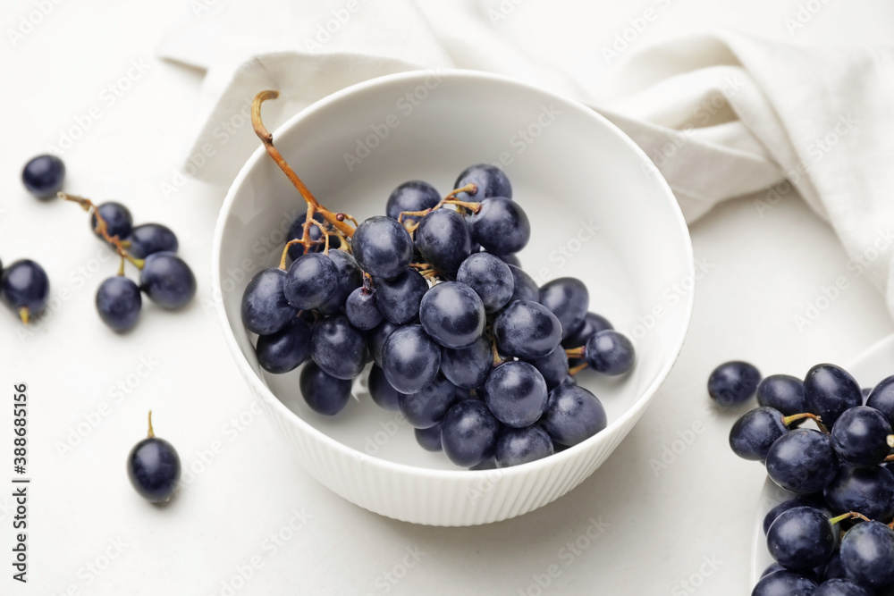 Bowl with sweet ripe grapes on table