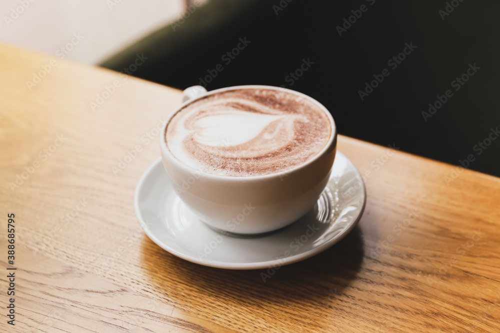 Cup of tasty cappuccino on table in cafe