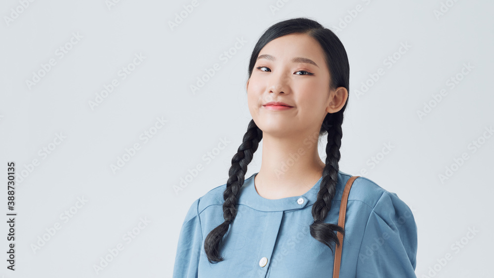 Portrait of a pretty girl holding backpack and looking at camera isolated over white background