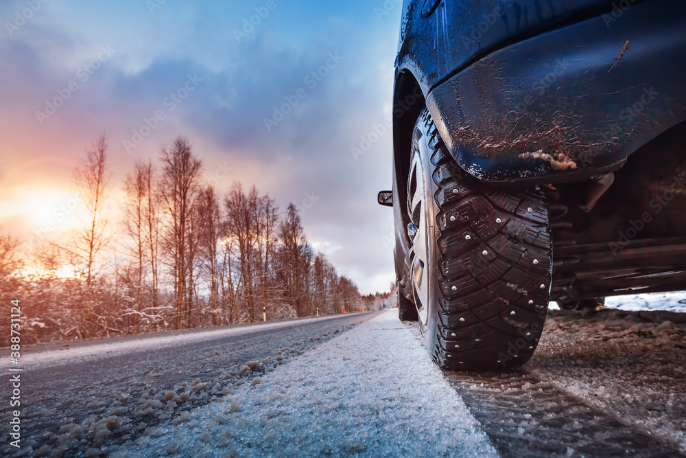 Car tires on winter road covered with snow