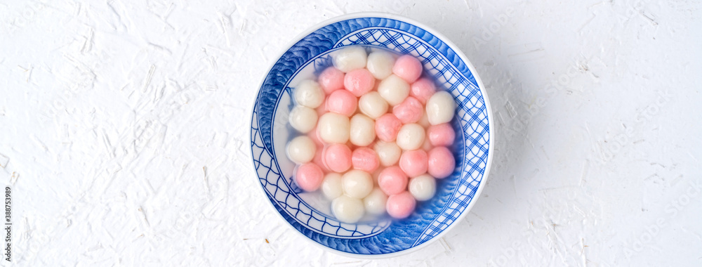 Top view of red and white tangyuan in blue bowl on white background for Winter solstice.