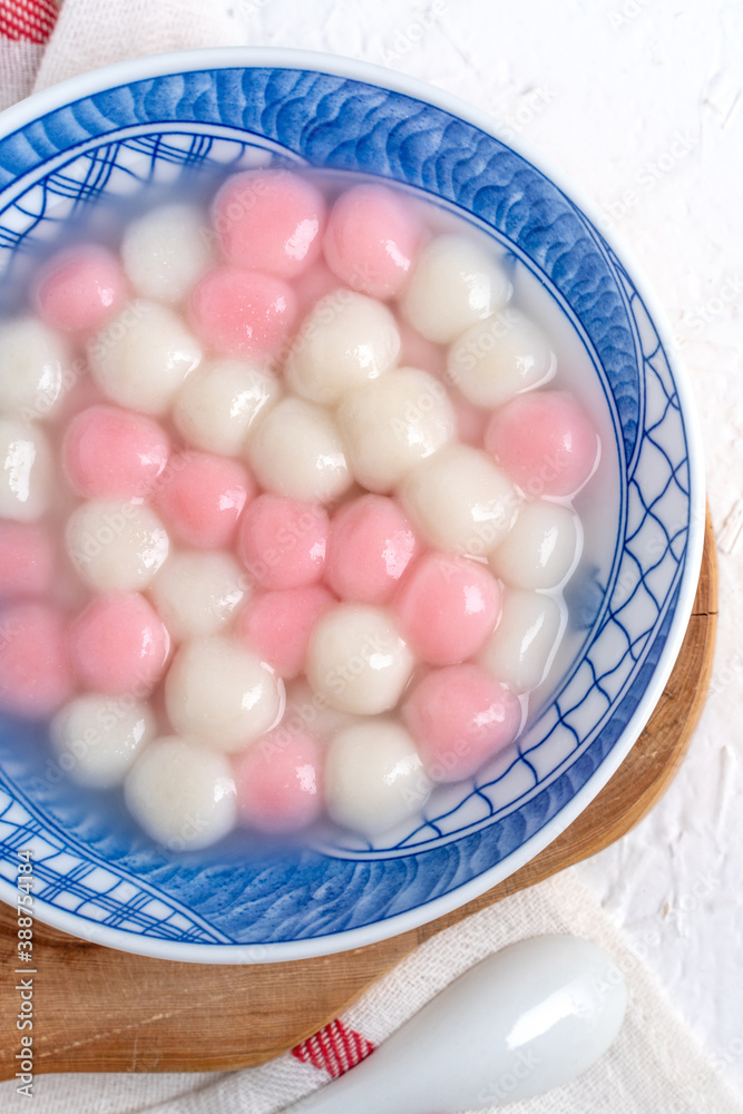 Top view of red and white tangyuan in blue bowl on white background for Winter solstice.