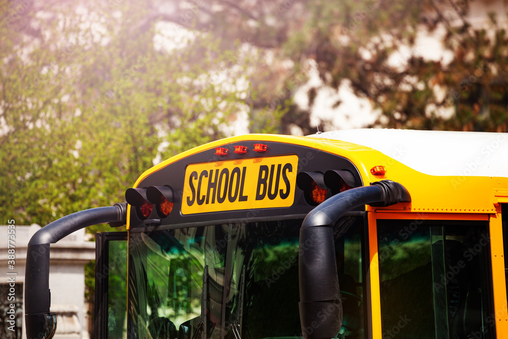 Close-up of yellow school bus windshield and sign on the parking