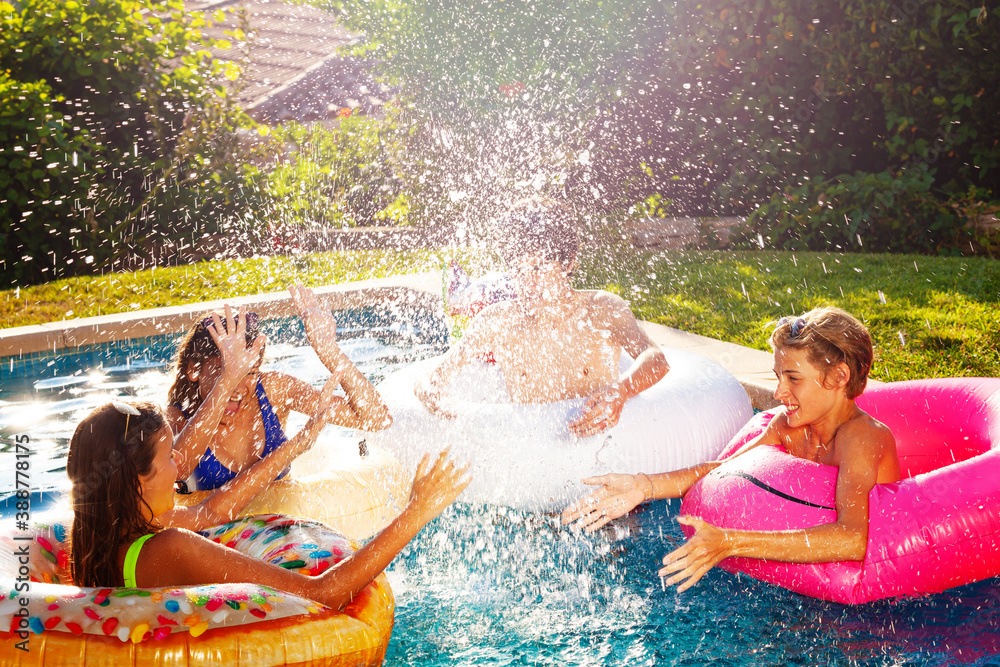 Many children splash in swim pool playing together outside have fun and laugh