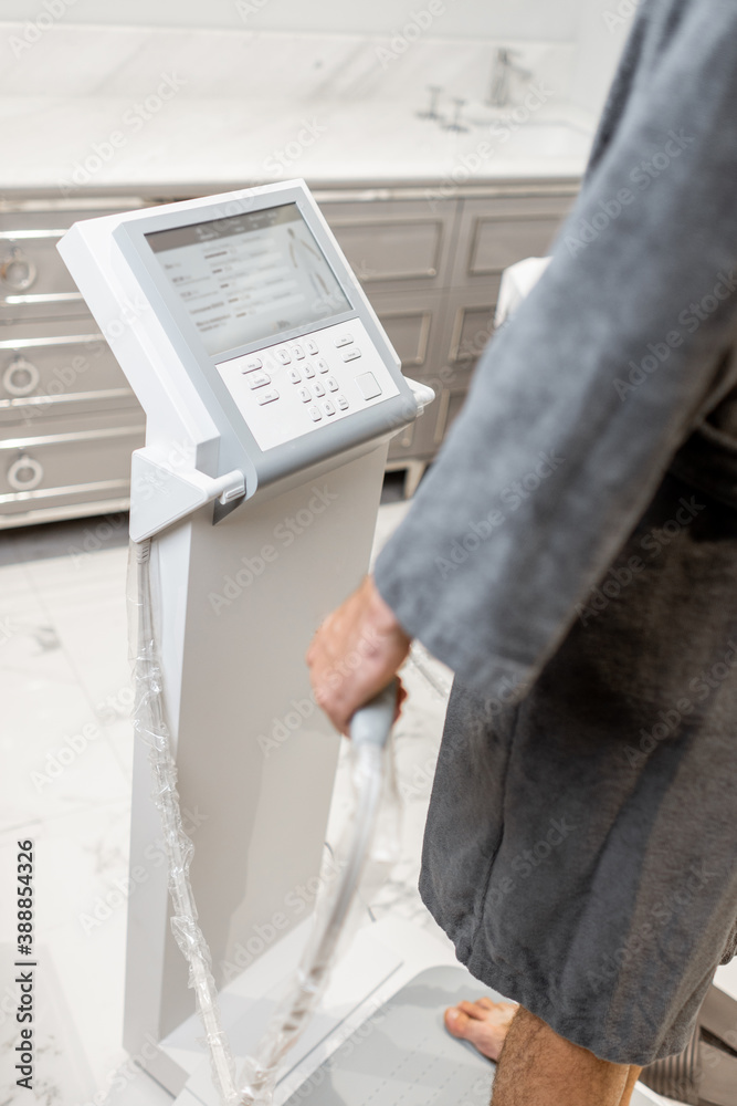 Man measuring body composition balance, holding handles of a medical scales during Inbody test