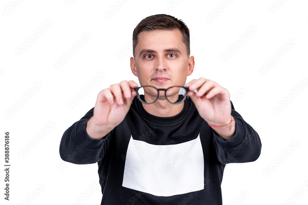 Young trendy guy with glasses smiling. White studio shot. A portrait of clever man looking at camera