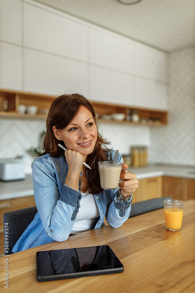 Sitting at kitchen, orange juice on the table.