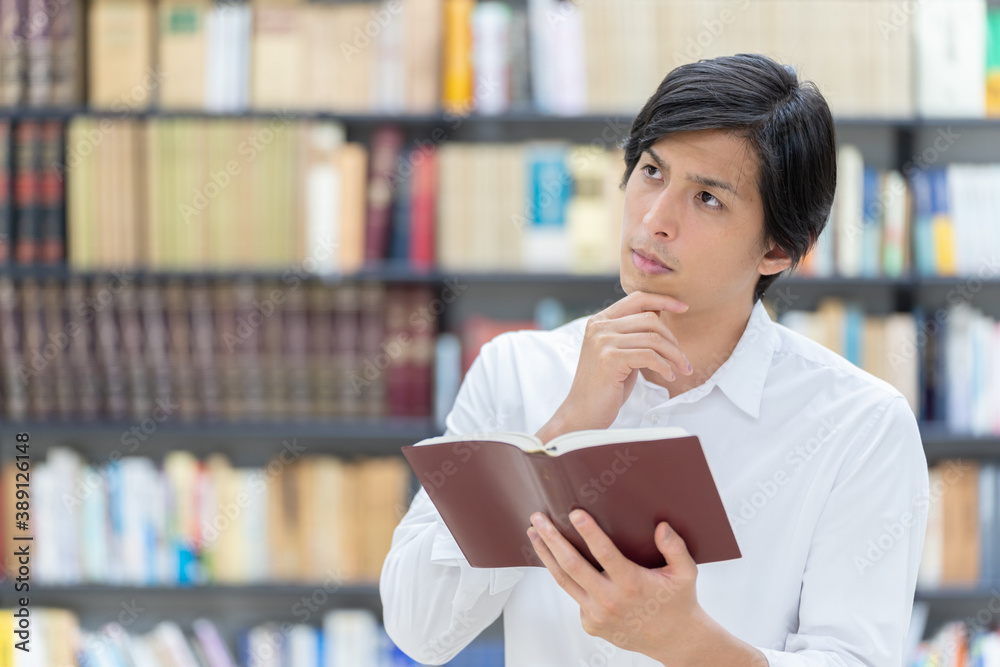 図書館で考え事をする男性