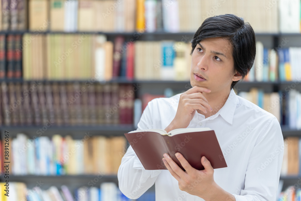 図書館で考え事をする男性