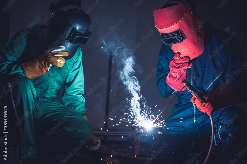 Metal welding steel works using electric arc welding machine to weld steel at factory. Metalwork man