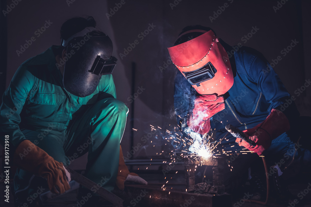 Metal welding steel works using electric arc welding machine to weld steel at factory. Metalwork man