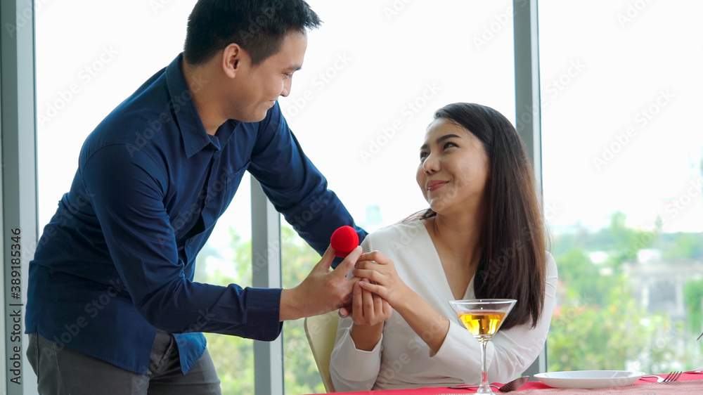 Romantic couple giving gift to lover at restaurant . Happy couple lifestyle .