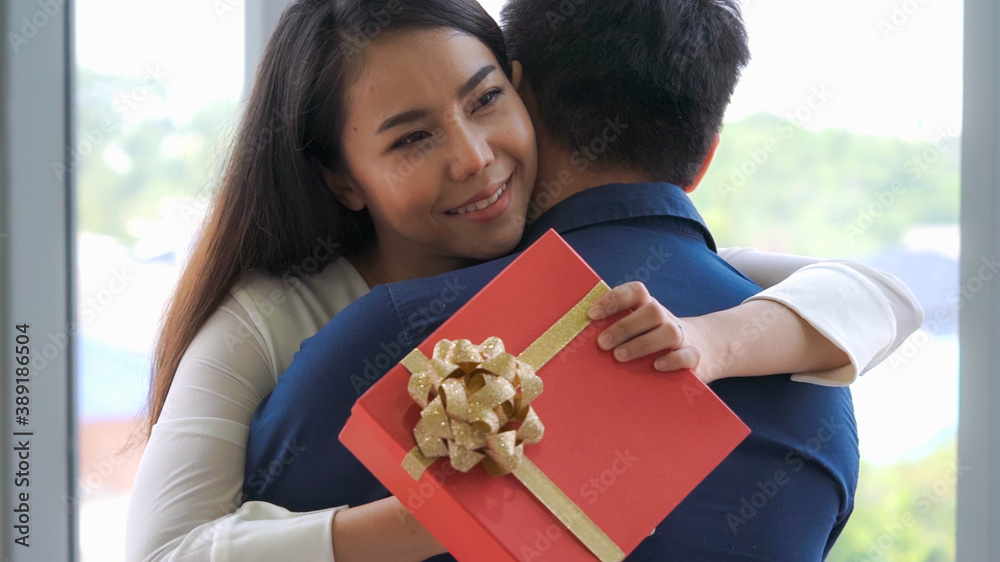 Romantic couple giving gift to lover at restaurant . Happy couple lifestyle .