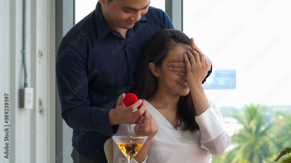 Romantic couple giving gift to lover at restaurant . Happy couple lifestyle .