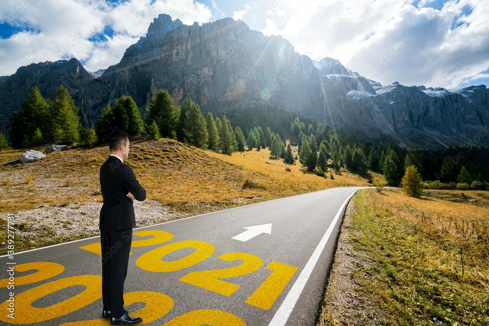 The 2021 New Year journey and future vision concept . Businessman traveling on highway road leading 