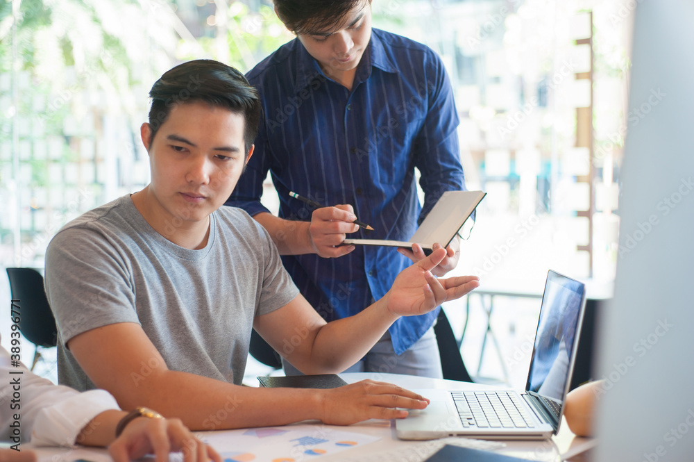 Young man working with colleagues in office.