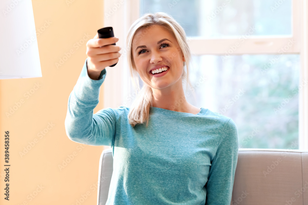 Young woman watching TV in her living room