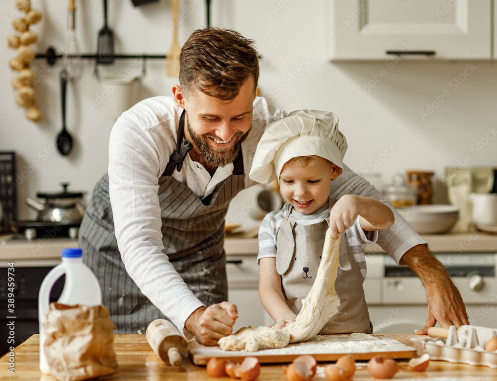 Father and little boy kneading dough together.