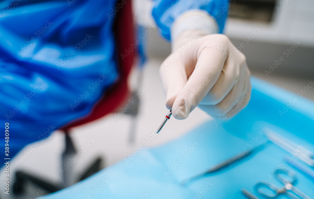 Dental prosthesis, artificial tooth. Dentist`s hands working on the denture. False teeth.