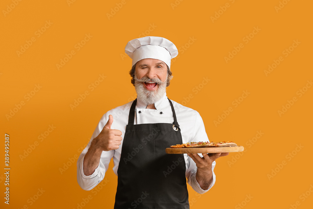 Mature male chef with tasty pizza on color background