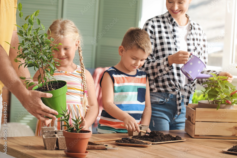 Young family setting out plants at home