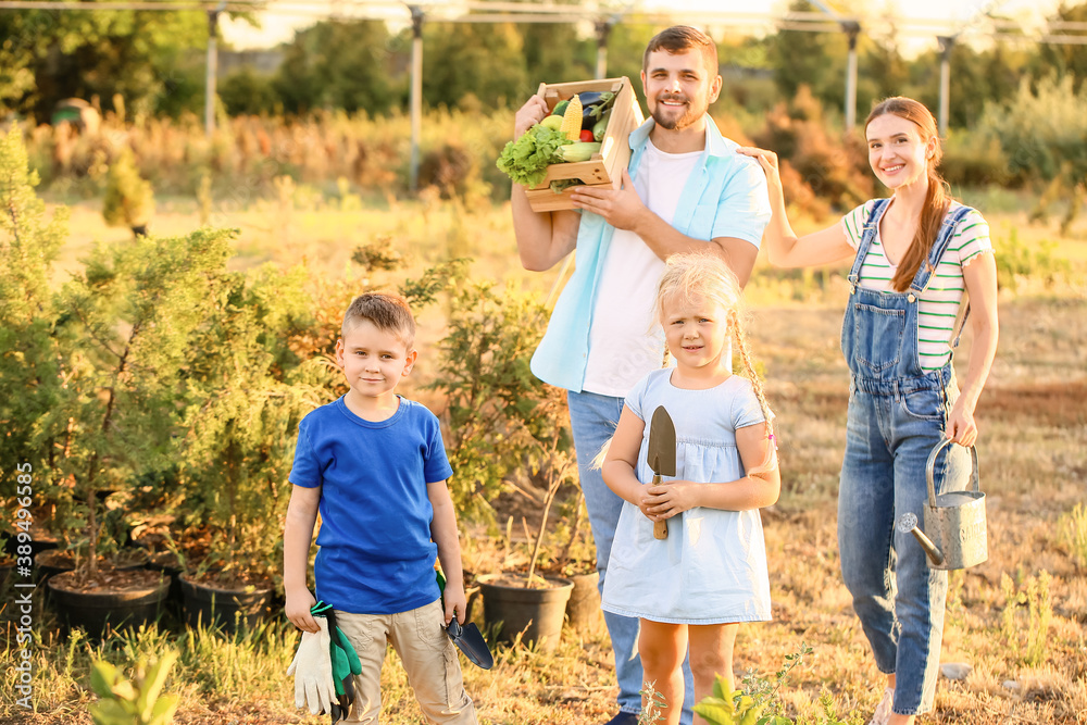 Young family with harvest in garden