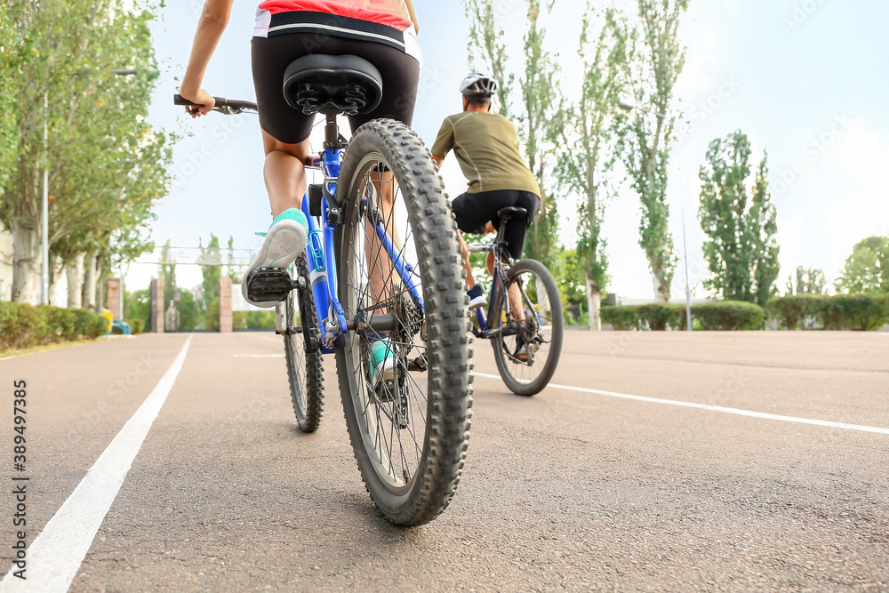 Sporty cyclists riding bicycles outdoors