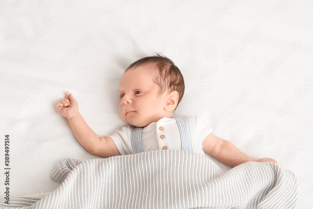 Cute little baby lying on bed