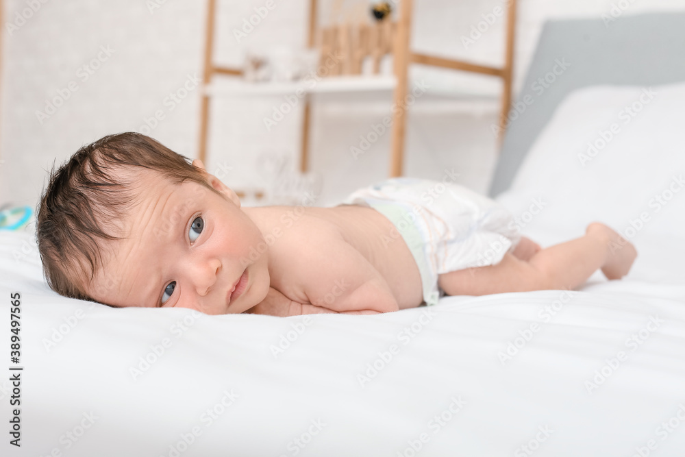 Cute little baby lying on bed at home