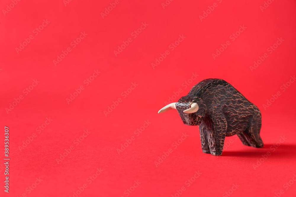 Figurine of bull as symbol of year 2021 on color background