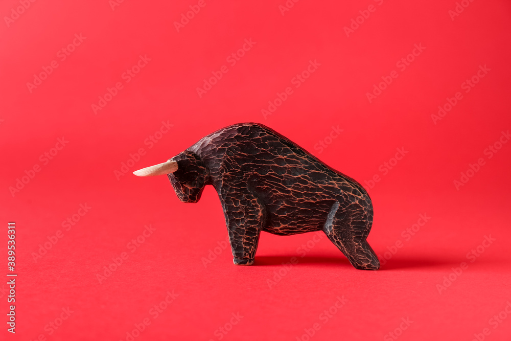 Figurine of bull as symbol of year 2021 on color background