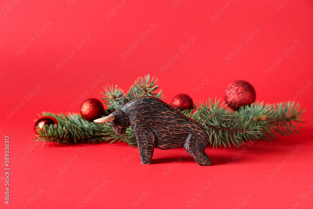 Figurine of bull and New Year decor on color background