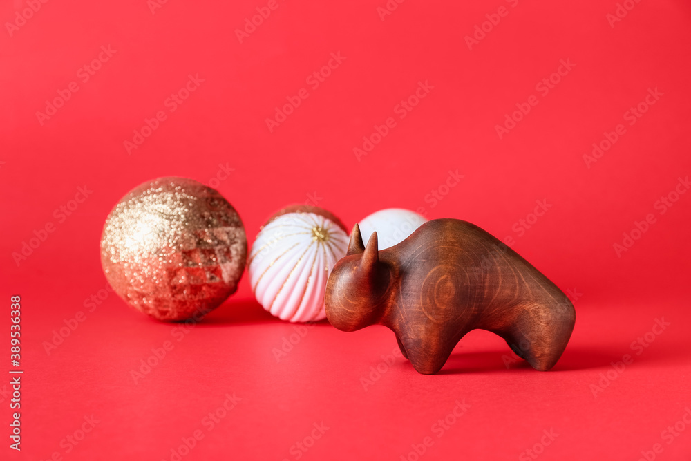 Figurine of bull and New Year decor on color background