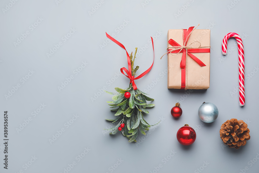 Christmas composition with mistletoe branch and decor on grey background