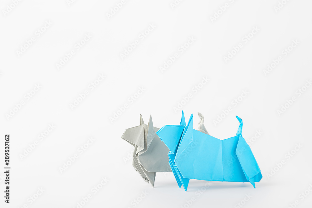 Origami bulls as symbol of year 2021 on white background