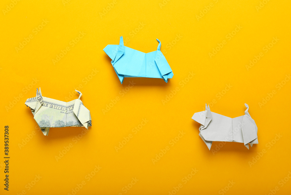 Origami bulls as symbol of year 2021 on color background