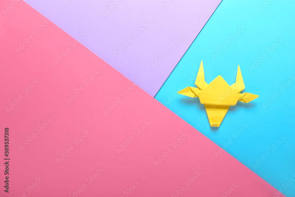 Origami bull as symbol of year 2021 on color background