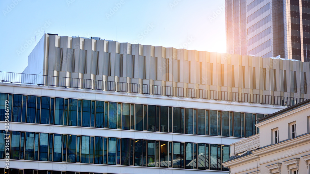 Blue curtain wall made of toned glass and steel constructions under blue sky. A fragment of a buildi